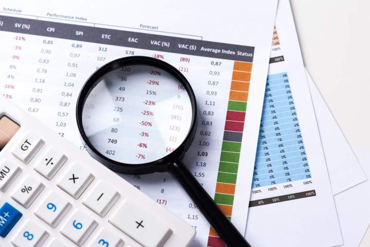 travailler avec une loupe une calculatrice et des papiers